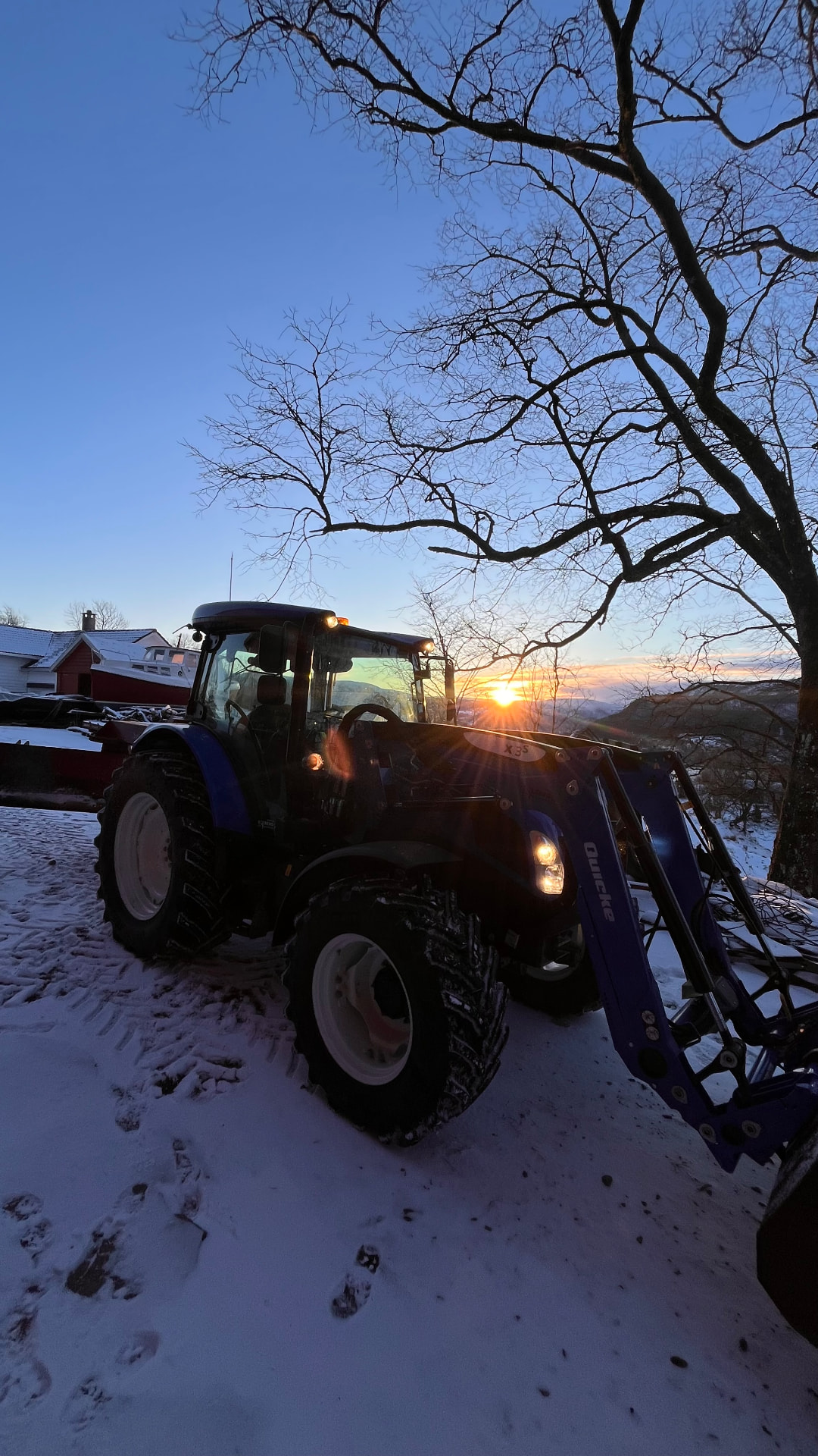 Traktor på snøkledd bakke i lågsol ved Totlandgard