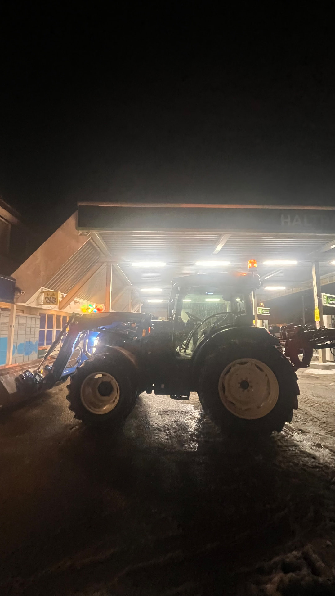 Traktor fylles drivstoff om kvelden